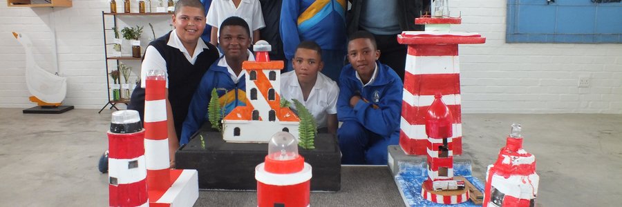 Hier is die groep leerders van Gansbaai Primêr by hulle vuurtorings wat hulle gebou het, met Adjunkhoof Niel Pedro agter regs 